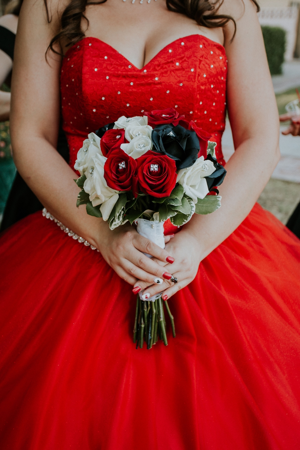 Bride in a red gown holding her bouquet