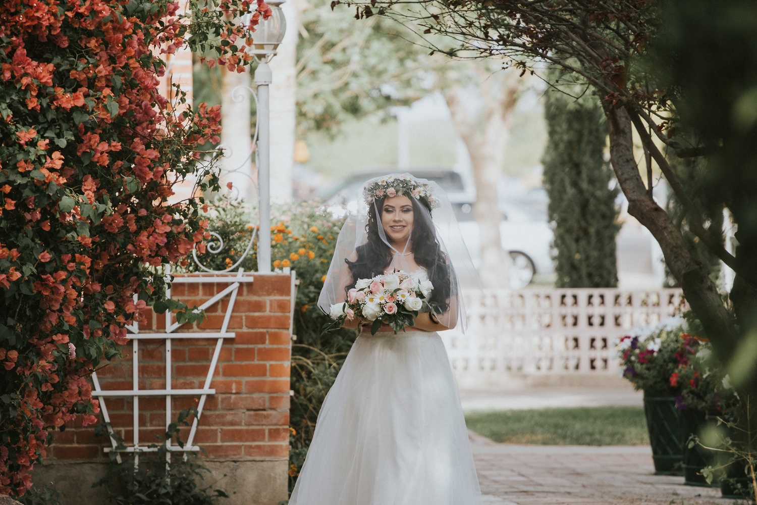 Bride walking beneath a flowering arbor