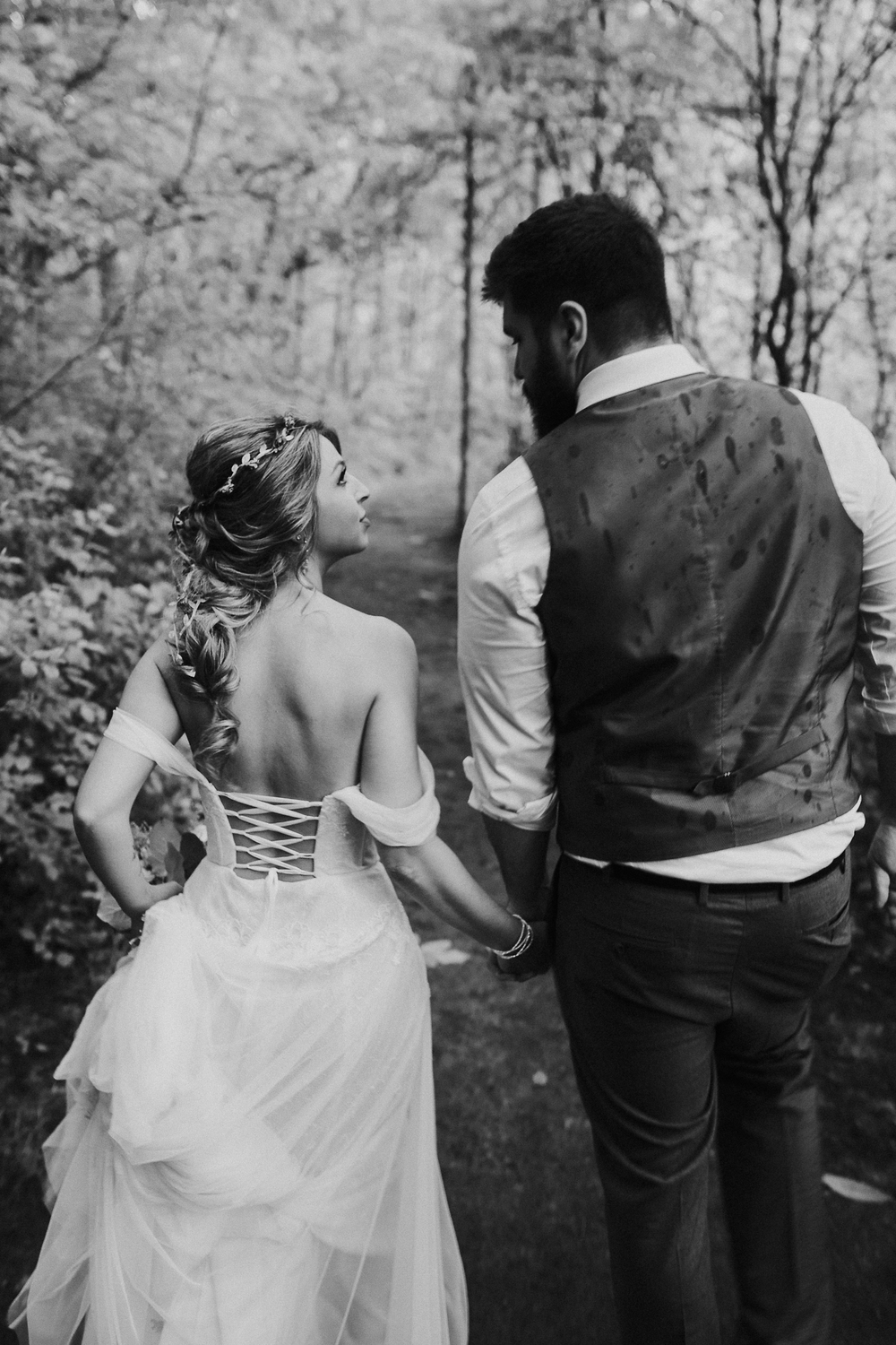 Couple walking hand in hand through the woods