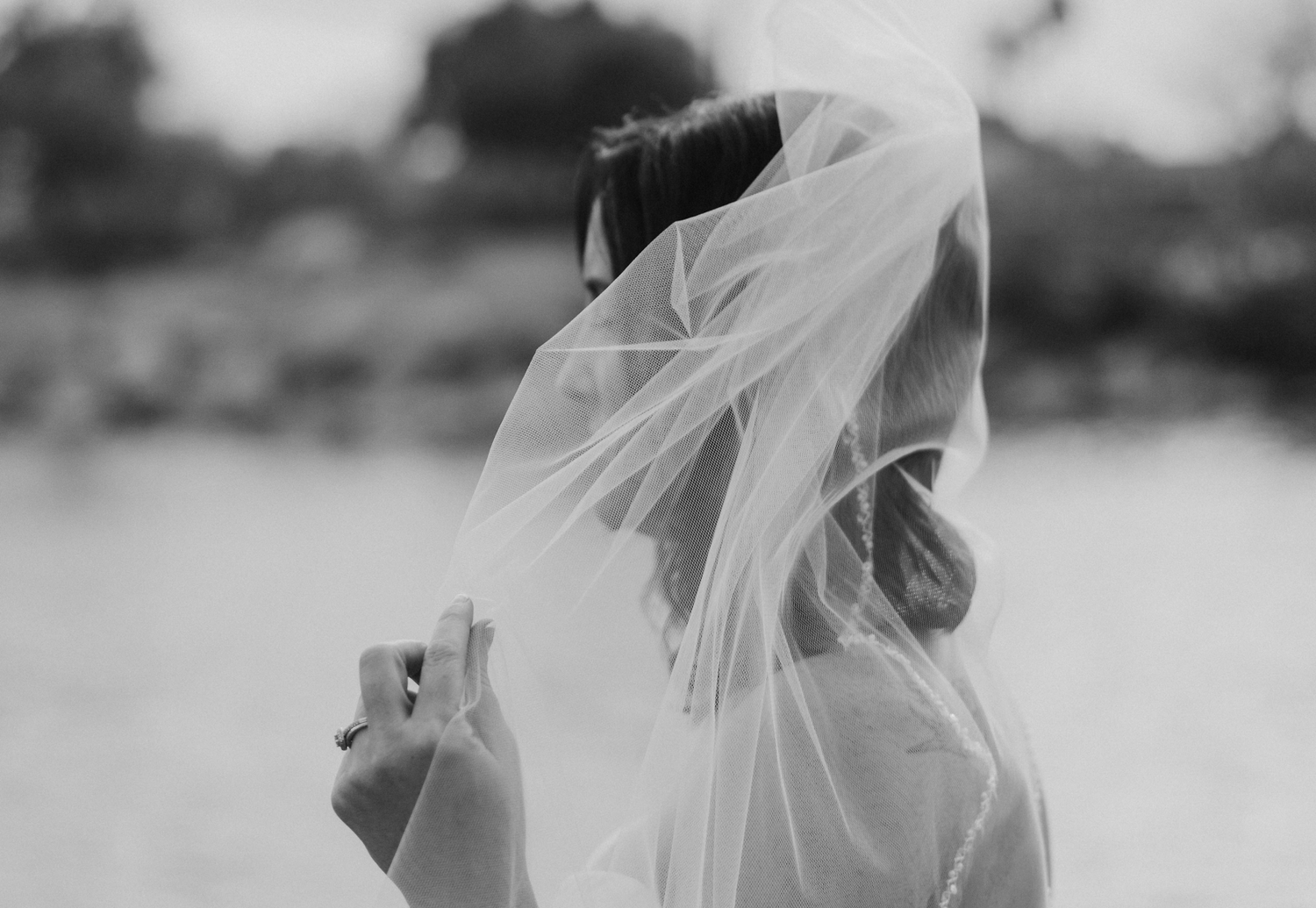 Bride lifting her veil in the wind