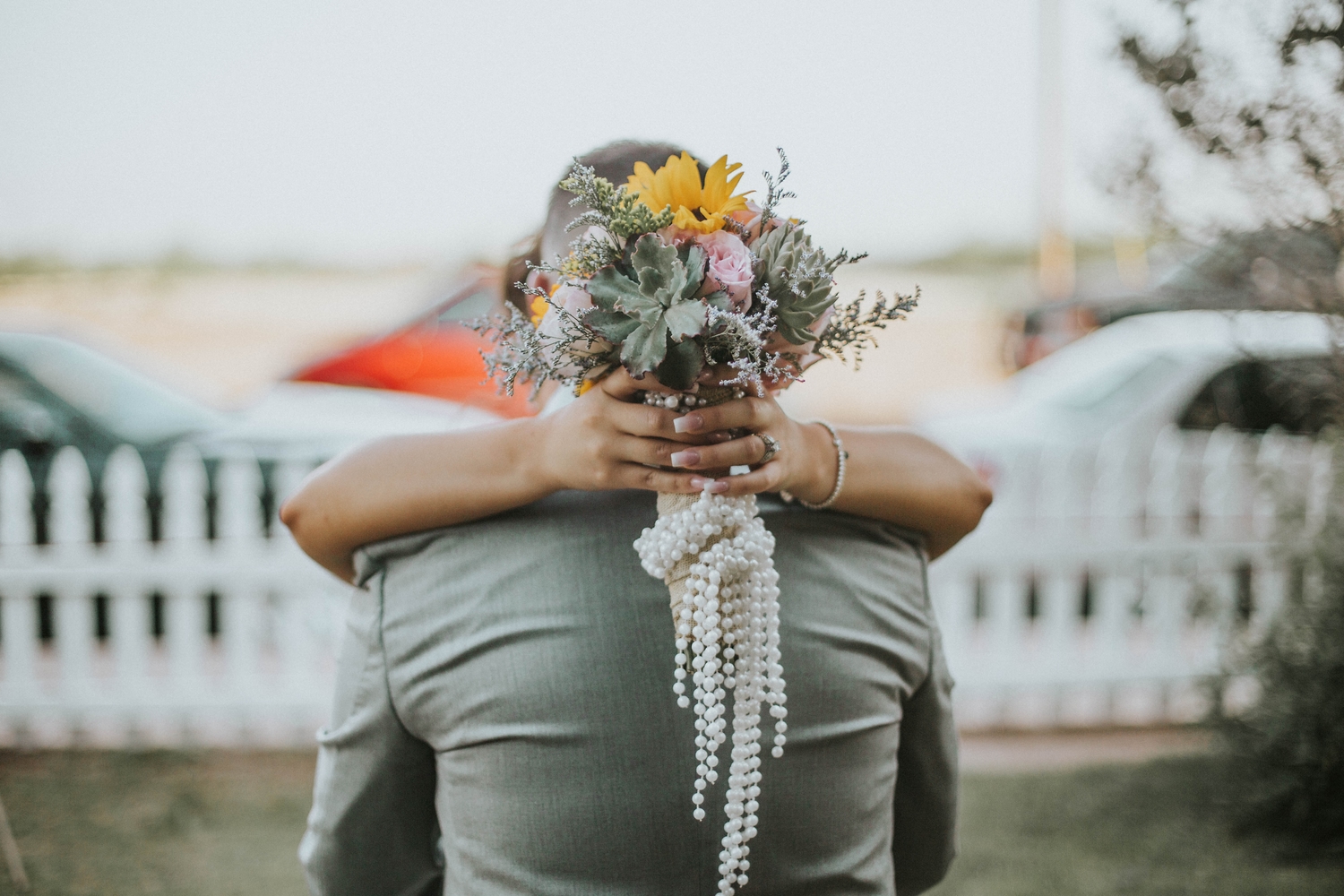 Couple embracing behind the bouquet